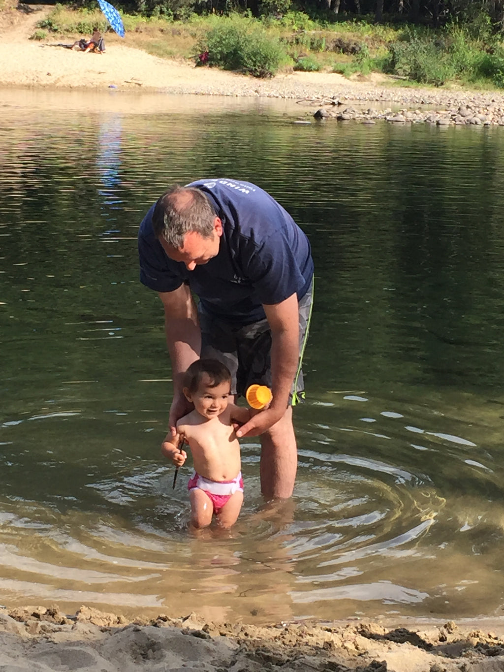 Man and child playing in a shallow clean water 