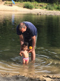 Man and child playing in a shallow clean water 