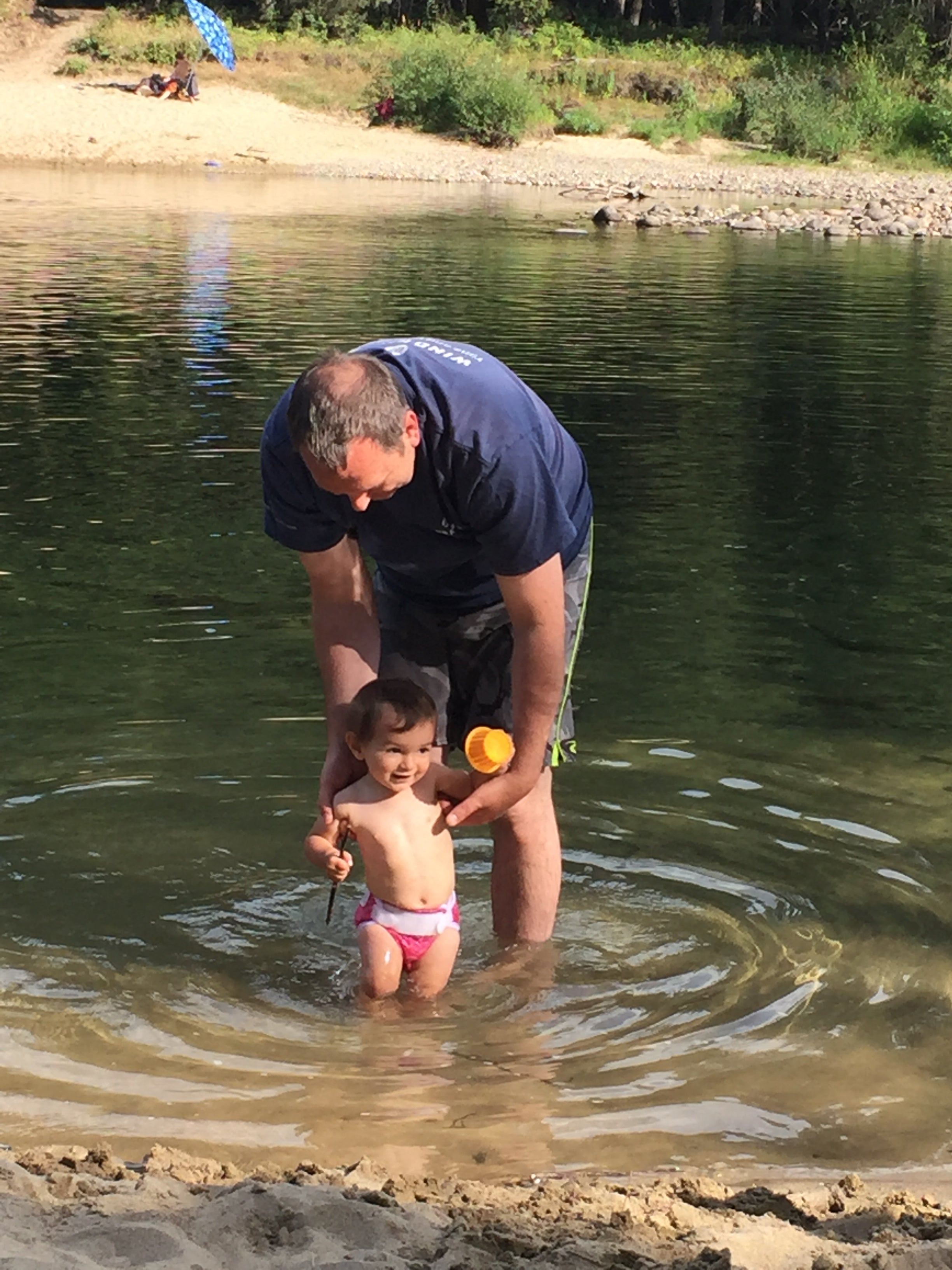 Man and child playing in a shallow clean water 